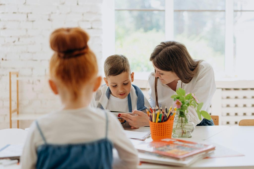 This is a photo of a homeschool teacher in working with students in their learning room at home.